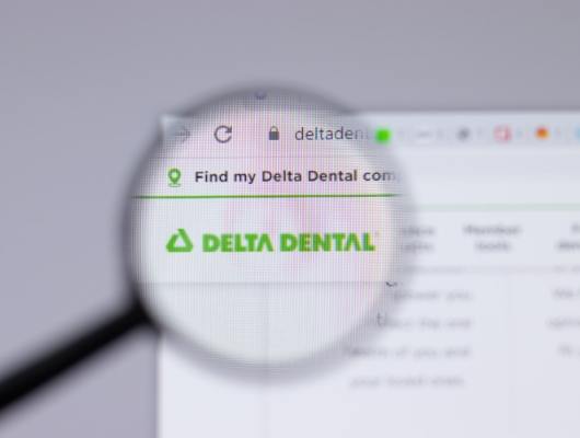 Magnifying glass in front of Delta Dental website on computer screen