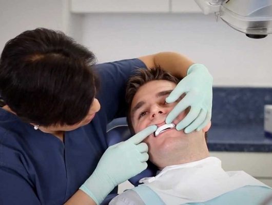 Dentist fitting a patient with a nightguard