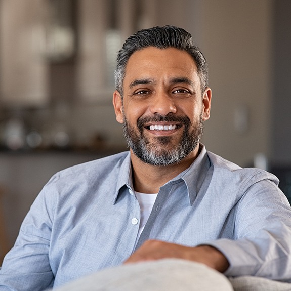A smiling, middle-aged man sitting in his living room