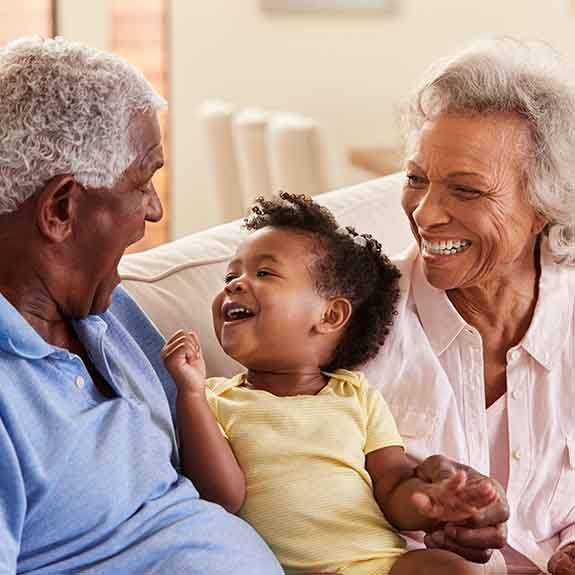 Grandparents smiling with grandchild after visiting United Healthcare dentist in Denton