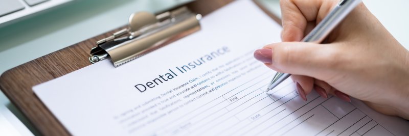 person filling out dental insurance paperwork