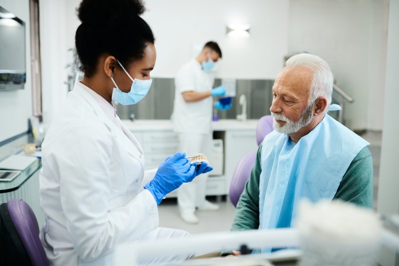 Dentist discussing dentures with male patient